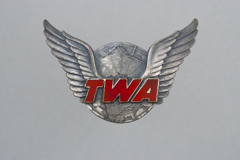 Image: gate agent hat badge: TWA (Trans World Airlines)