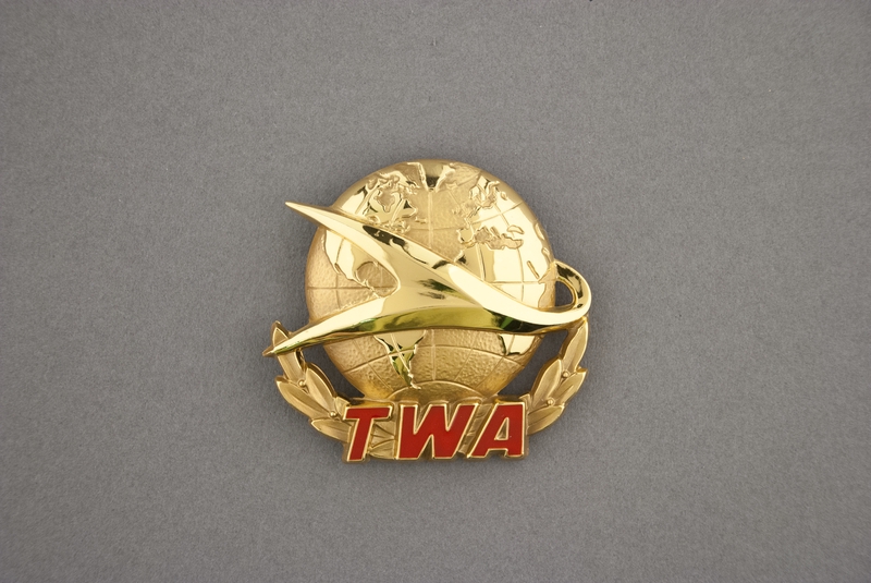 Image: flight officer cap badge: TWA (Trans World Airlines)