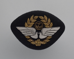 Image: flight officer cap badge: JAL (Japan Airlines)