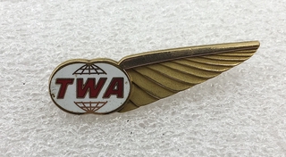 Image: air hostess hat badge: TWA (Trans World Airlines)