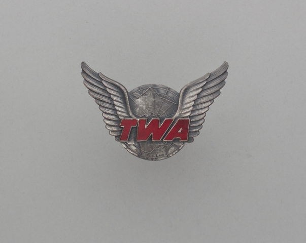 Gate agent hat badge: TWA (Trans World Airlines)