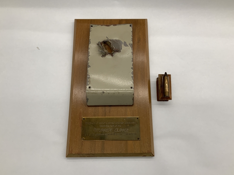 Image: plaque: Philippine Clipper fragment with .50 caliber bullet
